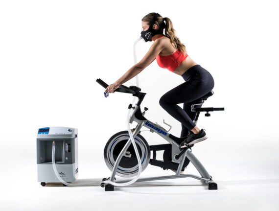 Trainer uses hypoxic machine and mask on cycle...